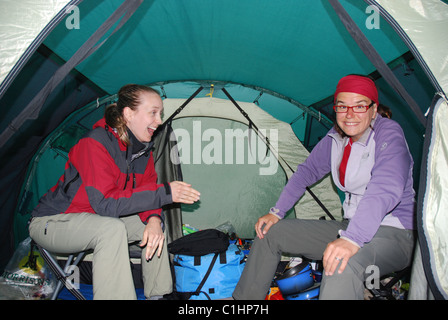 Two women laughing in a tent Stock Photo