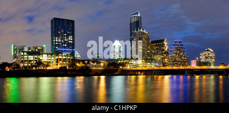 AUSTIN, Texas - Panorama of Austin's city skyline at dusk, with the lights reflecting on the water and the Congress Street Bridge at right. Stock Photo