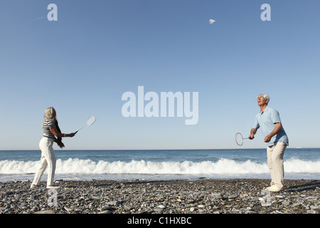 Senior couple playing badminton on beach, Italy Stock Photo