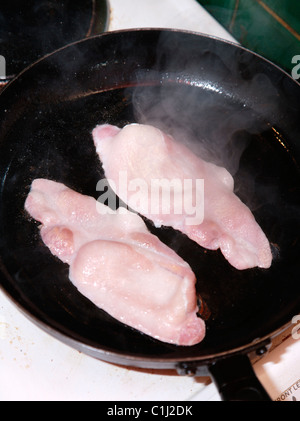 Bacon frying in pan Stock Photo