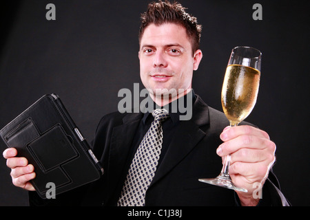 Businessman cheers with his tablet pad in one hand Stock Photo