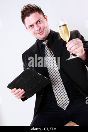 Businessman cheers with his tablet pad in one hand Stock Photo