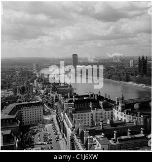 1960s, aerial view of River Thames from County Hall, showing the Victoria tower of the Palace of Westminster and Millbank, a modern tower block. Stock Photo
