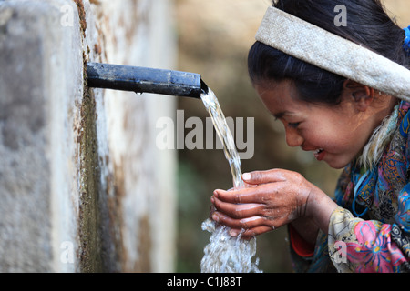 Nepali girl drinking water in Nepal Stock Photo