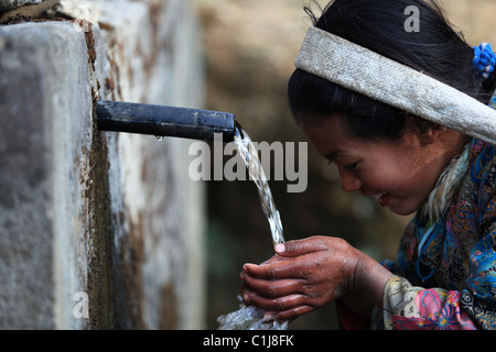 Nepali girl drinking water in Nepal Stock Photo