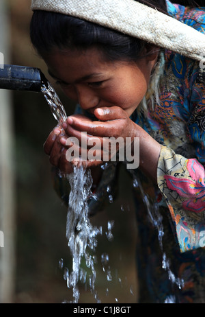 Nepali girl drinking water in Nepal Stock Photo