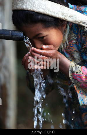 Nepali girl drinking water in Nepal Stock Photo