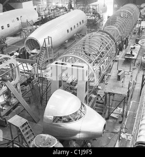 1950s, historical, civilian areoplanes under construction in a large hangar, showing the sections of shells, hulls and cockpit, London, England, UK. Stock Photo