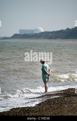 middle aged woman paddling in north sea near sizewell nuclear power station Stock Photo