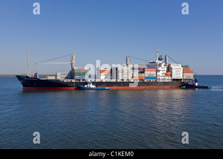 Container ship with two tugs arriving at the Port of Corinto, Nicaragua Stock Photo