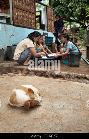 Girls washing dishes outdoors at a well in the Mae La refugee cam, Tak province, Thailand, Asia. Stock Photo