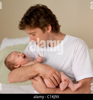 Crying Baby Held by Father Stock Photo