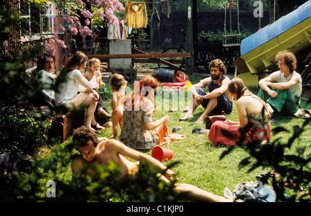 Hippy hippies members of a 1970s 70s hippie hippy commune sitting together with children talking at home in an urban Camberwell communal garden in the 1976 heatwave in the Summer of '76  (summer of 1976) South London England UK Great Britain  KATHY DEWITT Stock Photo