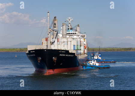 Container ship with two tugs arriving at the Port of Corinto, Nicaragua Stock Photo