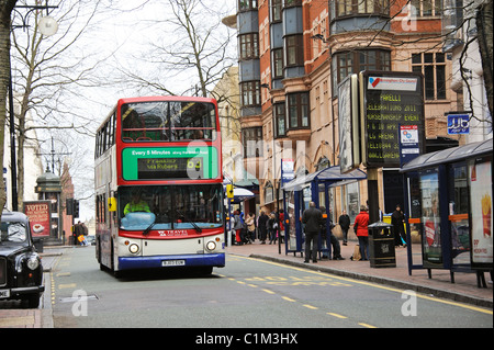 Bus stop and waiting passengers on Corporation Street in city centre Birmingham England UK Stock Photo