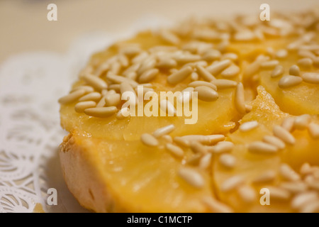 Close view of a homemade pineapple cake decorated with pine nuts. Stock Photo