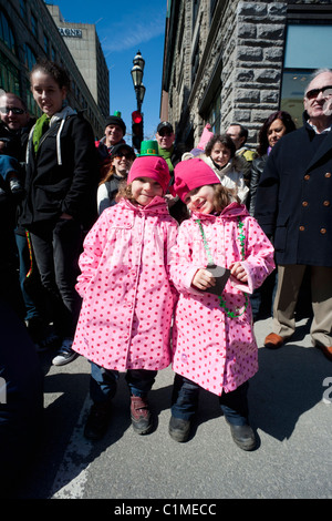 Twin sisters in matching pink raincoats attending the St Patricks parade in Montreal, Quebec, Canada Stock Photo