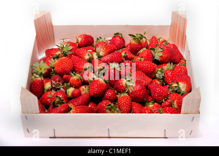 Close view of a wooden box filled with strawberries isolated on a white background. Stock Photo
