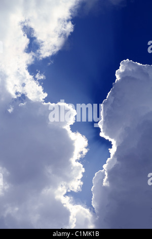 beams from sun in blue sky gray clouds skyscape background Stock Photo