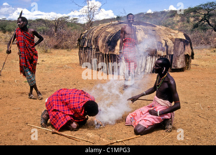 Samburu men making fire in village, Kenya Stock Photo