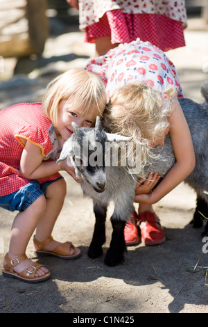 Girl embracing goat at zoo Stock Photo
