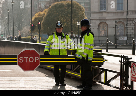 Two police officers guarding the stop sign at the Houses of Parliament, London. Stock Photo