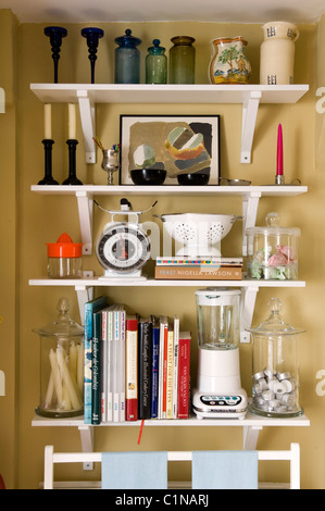 Assorted cookery items and books on open shelving Stock Photo