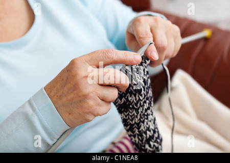 hands of an elder woman doing knitting at home Stock Photo