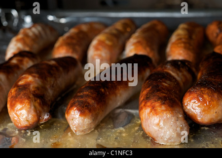 Sausages being cooked under electric grill Stock Photo