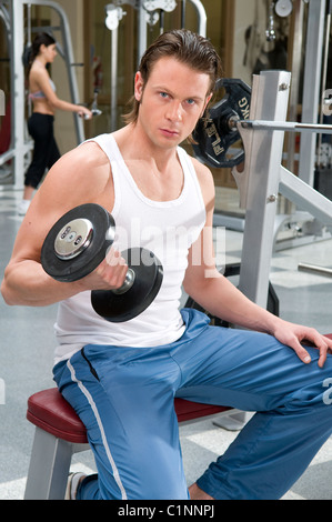 Image, looking, at, the, camera, train, training, do, doing, weights, lifting, exercise, exercising, holding, held, hold. Stock Photo
