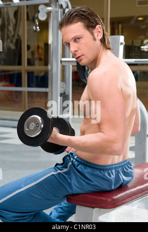 Image, man, looking, at, the, camera, backwards, train, training, do, doing, weights, lifting, exercise, exercising. Stock Photo