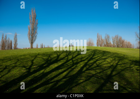 A council tractor approaches as it cuts the grass in a council run park in Basildon, Essex. UK. Stock Photo