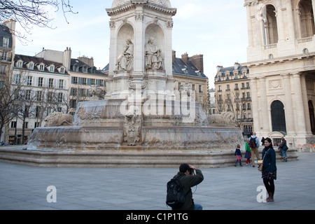 Tourists snapping a photo in the square in front of Eglise St. Sulpice in Paris France. Church of St. Sulpicius. Stock Photo