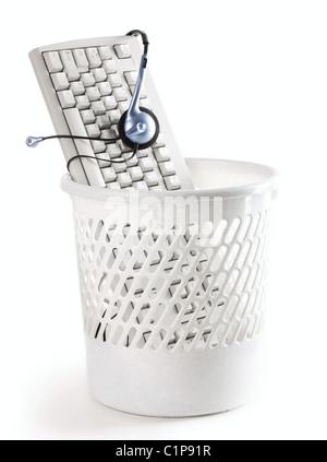 Image of computer keyboard with headphones in the trash bin Stock Photo