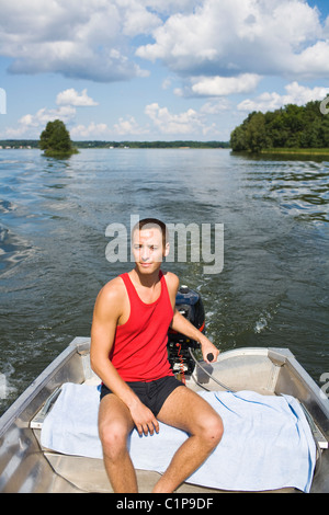 Young man on motorboat Stock Photo