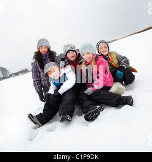 Portrait of children sitting in snow Stock Photo