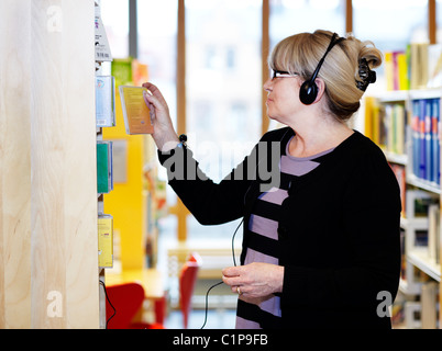 Woman wearing headphones in library