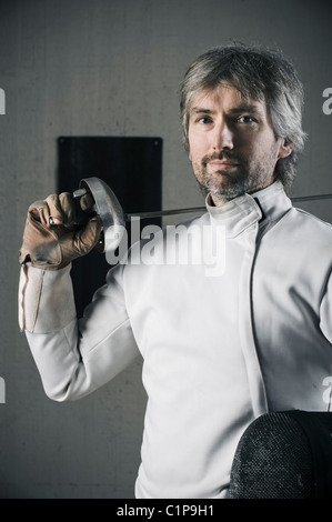 Portrait of male fencer in sports hall Stock Photo
