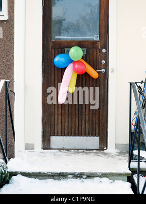 Colorful balloons hanging on door Stock Photo