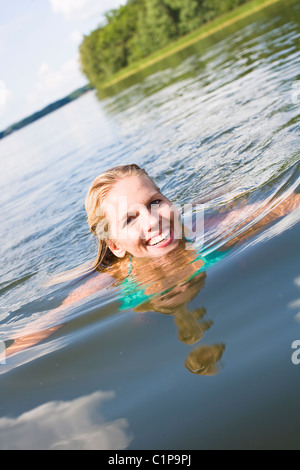 Young woman swimming in lake Stock Photo