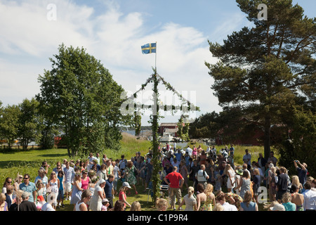 People standing under maypole Stock Photo