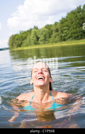 Young woman swimming in lake Stock Photo