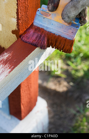 Hand in glove holding paintbrush and painting Stock Photo