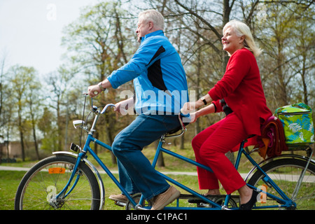 Senior couple riding on tandem bicycle Stock Photo