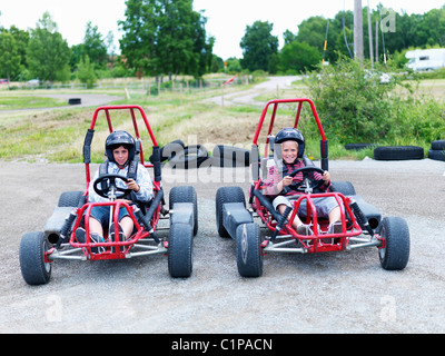 Portrait of two boys in go-carts on track Stock Photo