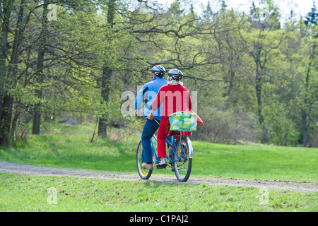 Senior couple riding on tandem bicycle Stock Photo