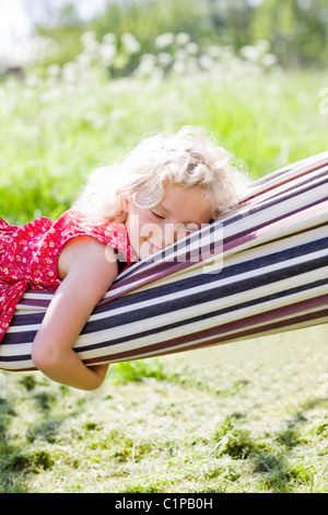 Girl sleeping in hammock in field Stock Photo