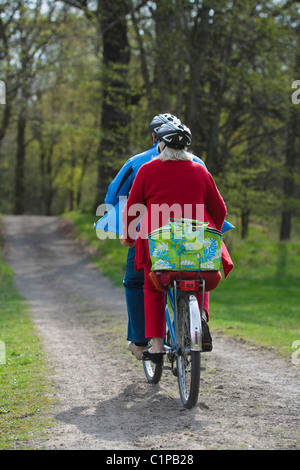 Senior couple riding on tandem bicycle Stock Photo