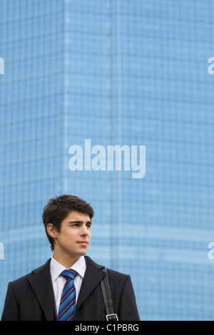 Image of pensive guy looking aside on the background of modern office building Stock Photo