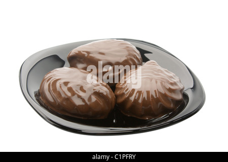 three zephyr in chocolate on black plate isolated on white Stock Photo